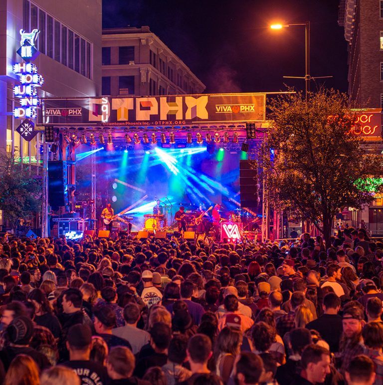 Crowd at outdoor stage under DTPHX sign