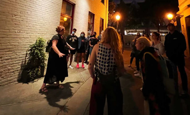 People standing around a host on a ghost tour