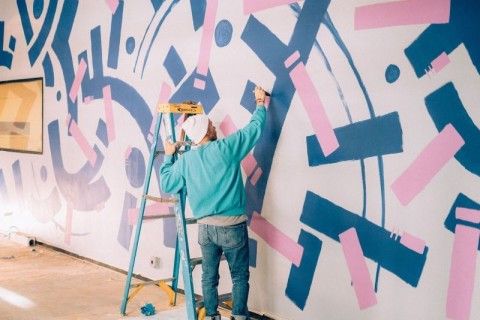 Artist painting walls blue and pink