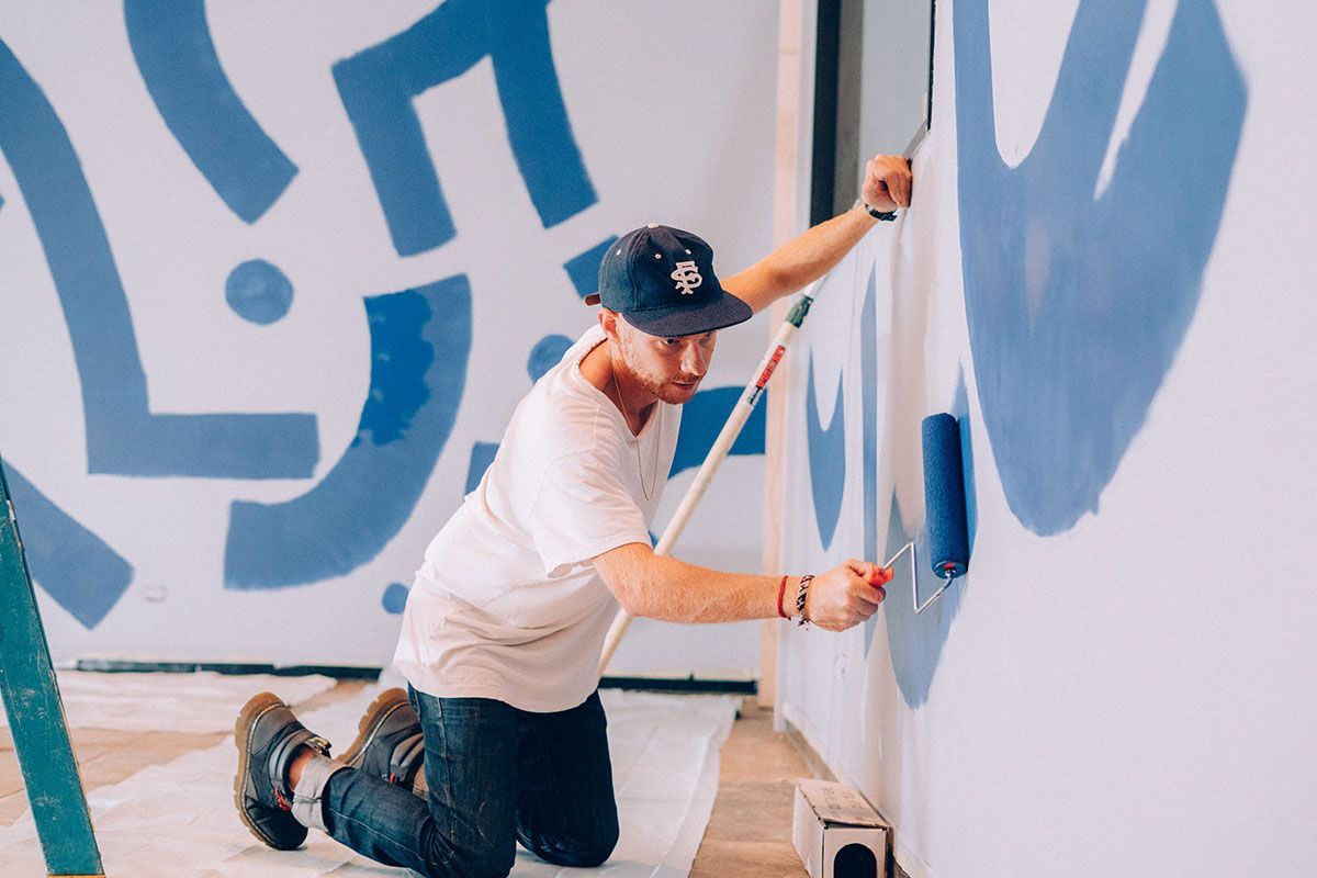 Artist paining blue design on wall