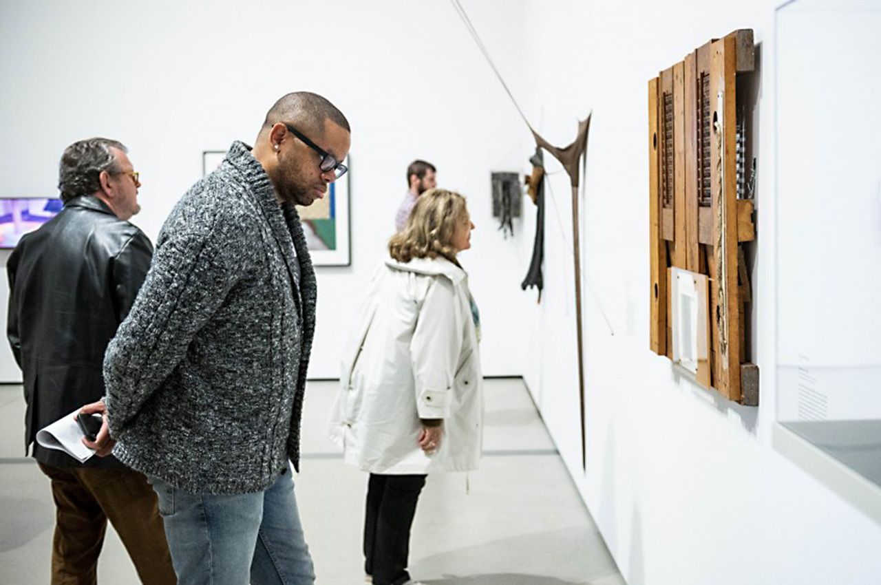 Man looking at art on gallery wall