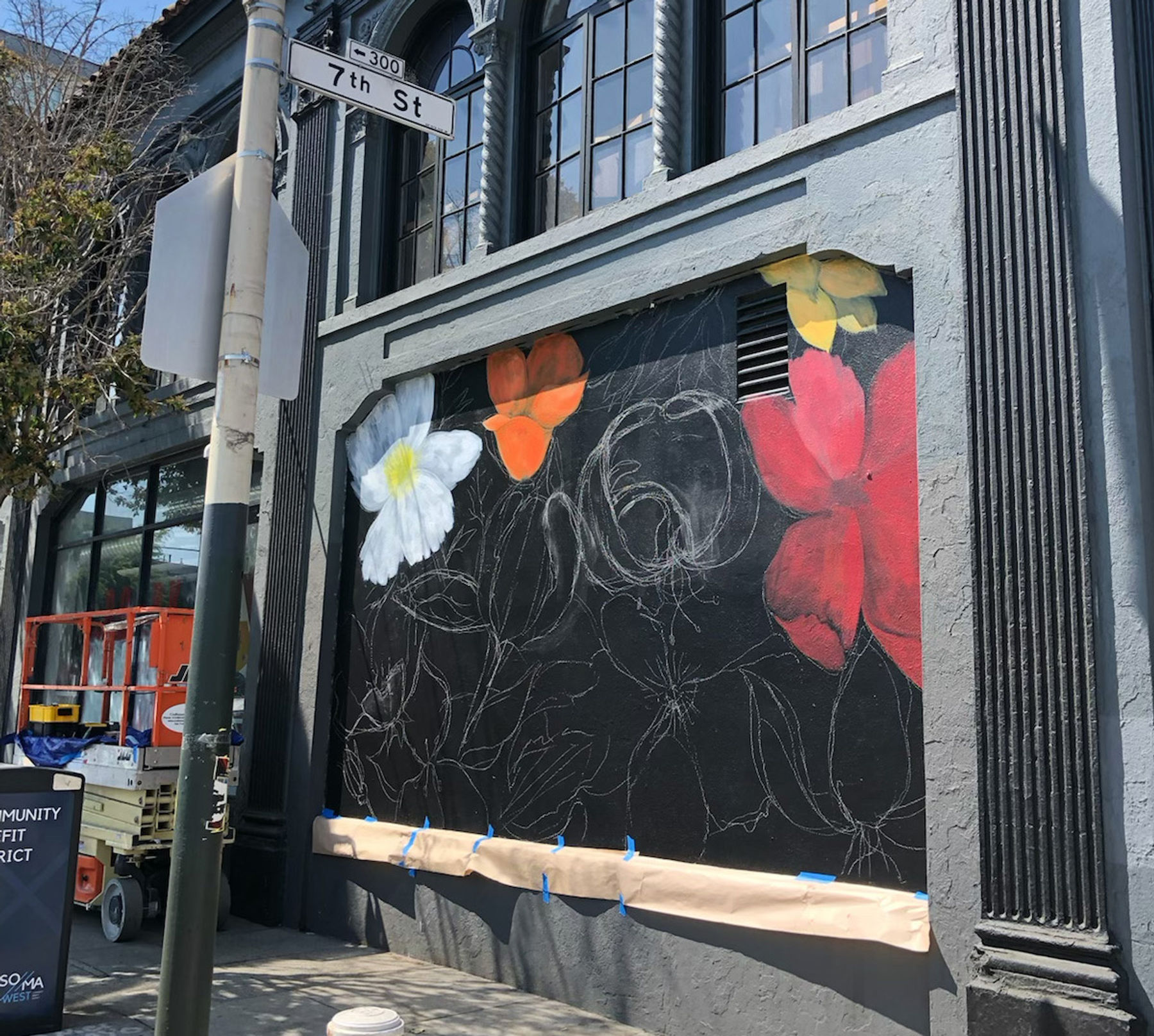 Mural preparation, sketch of flowers in chalk against a black background on a the wall