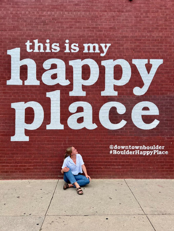 alexandra in front of happy place mural