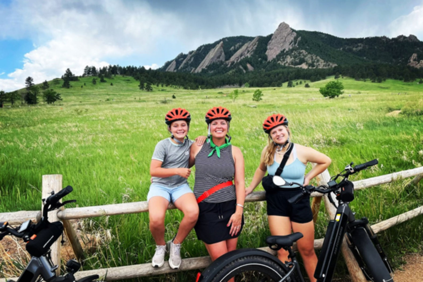 family on bikes in front of flatirons