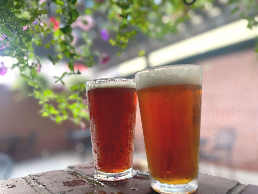 Two pints on patio with flowers at Crown Pub