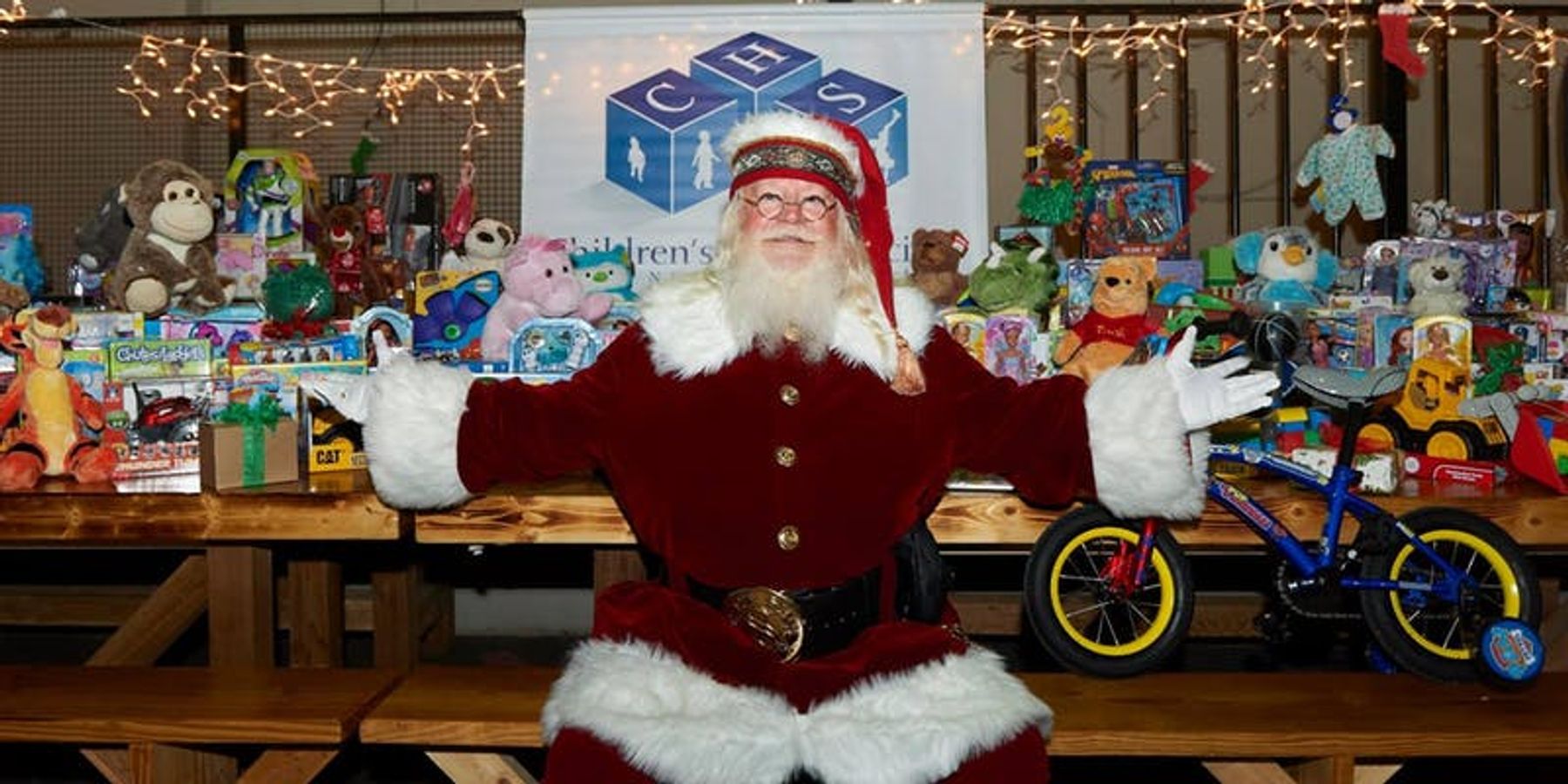Santa Claus sitting at table with toys