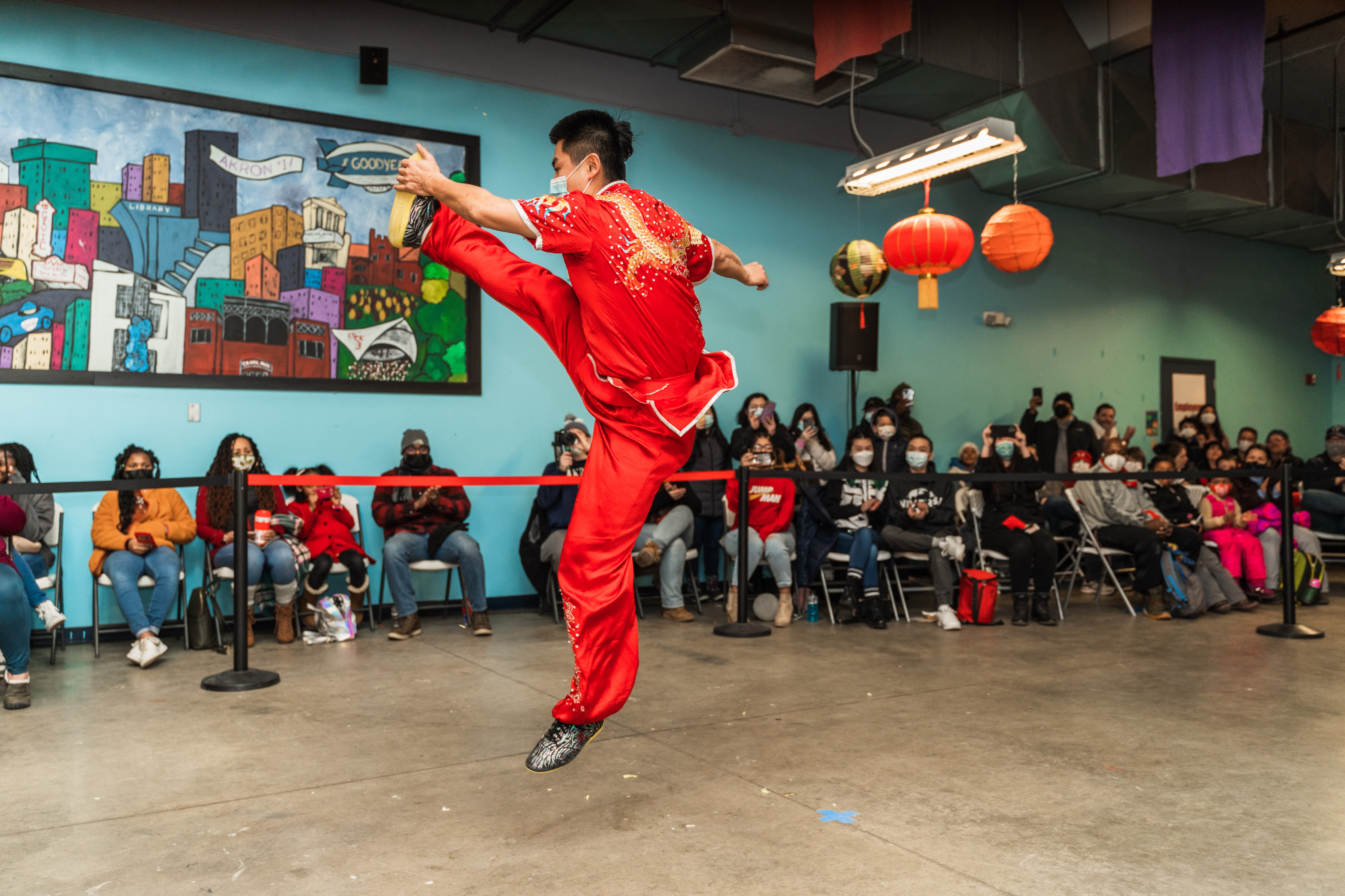 Kung Fu master dressed in red, leaping in the air during a martial arts routine