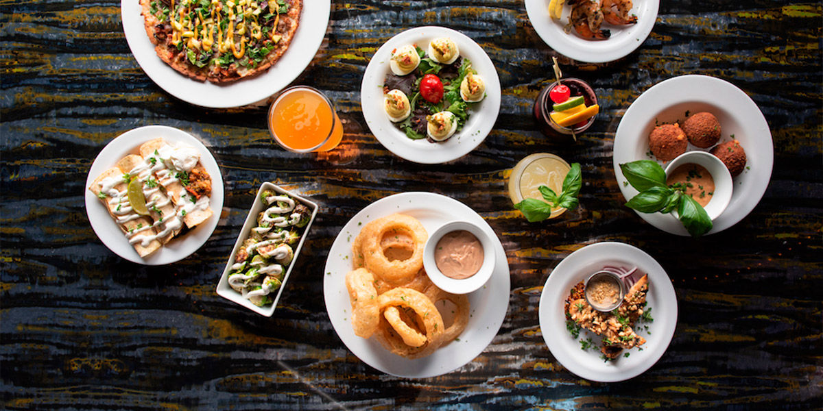 An aerial view of a black table filled with food and drink dishes from Jilly's Music Room in downtown Akron.
