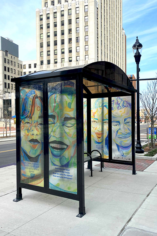 Photograph of downtown Akron, Main St. METRO RTA bus shelter with We Are artwork